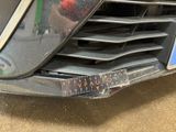 a close up of a car ' s grille with a sticker on it