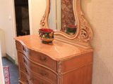 a dresser with a mirror on top of it in a room