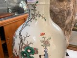a white vase with a picture of a woman and a bird on it
