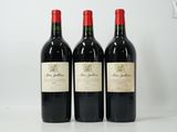 trois bouteilles de vin rouge posées sur une table blanche