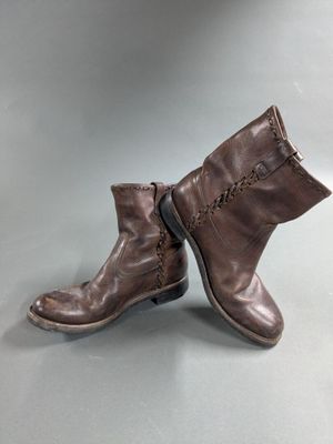 a pair of brown leather boots on a gray surface