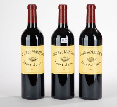 trois bouteilles de vin rouge posées l'une à côté de l'autre sur une surface blanche