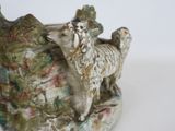 a figurine of a sheep that is sitting on a rock