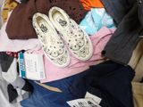 a suitcase full of clothes and shoes on a bed