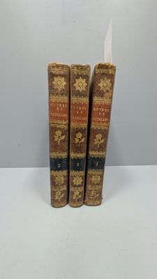 trois livres posés sur une table blanche, l'un à côté de l'autre