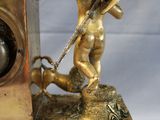 a statue of a man holding a clock on a table