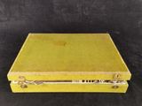 an old yellow suitcase sitting on top of a black table