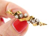 a woman ' s hand holding a red manicure with a pearled ring on it