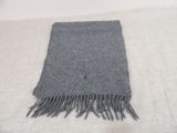 grey scarf with fringes on a white blanket on a bed