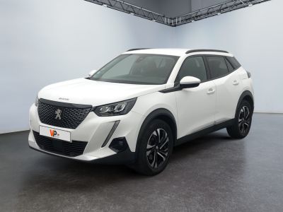 La voiture blanche est garée dans une grande pièce au sol noir.