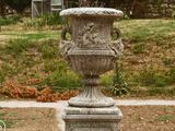 deux vases posés sur un socle au milieu d'un parc