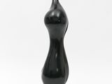 a black sculpture sitting on top of a wooden base