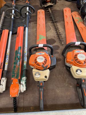 de nombreux modèles de tronçonneuses exposés dans un garage