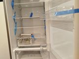a refrigerator that has been painted white and has blue tape on the door