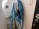 un tuyau bleu fixé au mur, à côté d'une porte noire