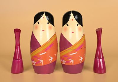 two dolls sitting next to each other on a table