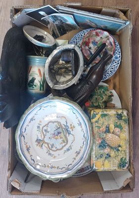 une boîte remplie d'objets divers posée par terre