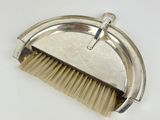 a close up of a brush with a metal handle on a white surface