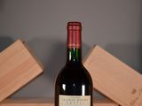 a bottle of wine sitting on a table next to a wooden box