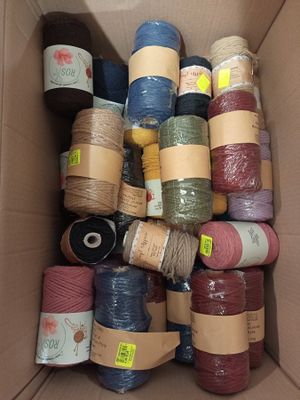 a box full of different colored yarns in it