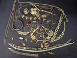 a lot of gold jewelry on a black table