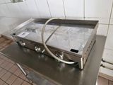stainless steel counter top with a gas stove on it in a kitchen