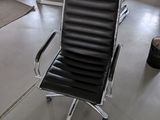 a black leather office chair in the middle of a room