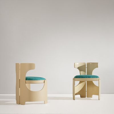 une paire de chaises dans une pièce blanche, avec un coussin bleu