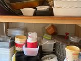 many dishes and containers on the shelf in the kitchen