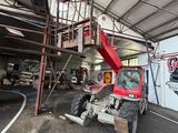 a red truck parked inside of a building with a ladder