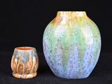 deux vases posés l'un à côté de l'autre sur une surface noire