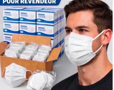 a man wearing a face mask next to a box of face masks
