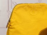 a yellow bag with a red handle sitting on a table