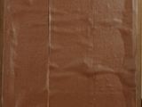 a brown piece of cardboard on a table with a brown piece of paper on top of it