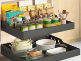a black pull out shelf in the corner of a kitchen with dishes and utensils on it