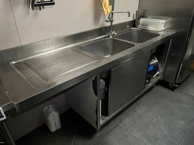 un évier en acier inoxydable dans une cuisine avec un plan de travail en acier inoxydable