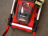 a red lawn mower that is laying on the ground