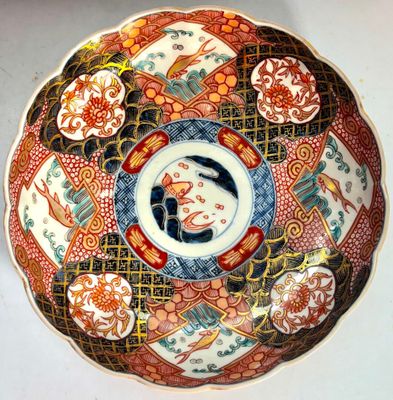Un plat Imari japonais aux motifs de poissons, pivoines et v…