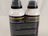 two bottles of black and white paint sitting on a white surface