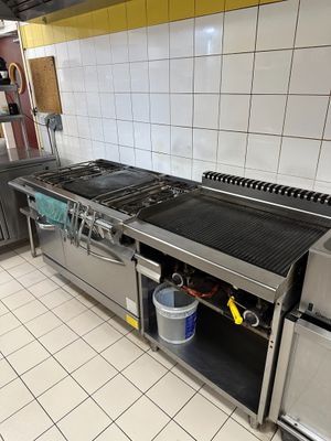 une cuisine équipée d'une cuisinière, d'un évier et d'un réfrigérateur
