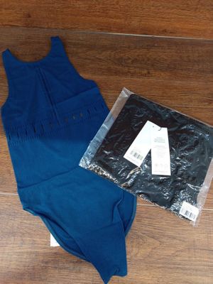 une robe bleue et une chemise noire sur un parquet