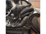 an image of a bronze statue of a woman sitting on a couch