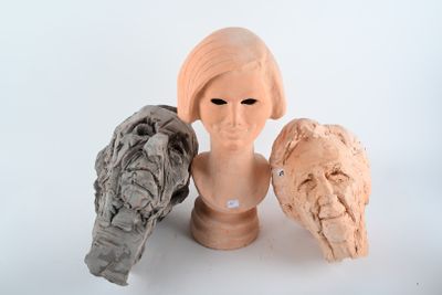trois sculptures en argile représentant une femme et un oiseau, posées sur une table
