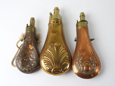 three antique brass bottle shaped ornaments on a white background