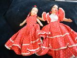 two dolls that are sitting on a black surface