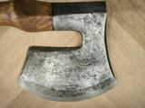 a large axe with a wooden handle sitting on a table