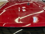 a close up of a red sports car in a showroom