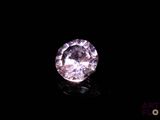 a close up of a pink diamond on a black surface