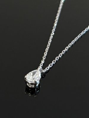 collier en argent orné d'un diamant en forme de larme sur un fond noir