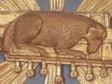 a gold sculpture of a dog laying on top of a sunburst